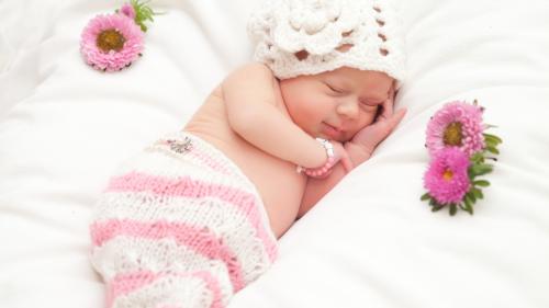 Маленькая девочка спящая с цветами