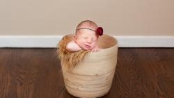 Маленький малыш спит в корзинке по среди комнаты