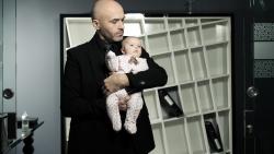 Маленький ребенок на руках у мужчины в костюме